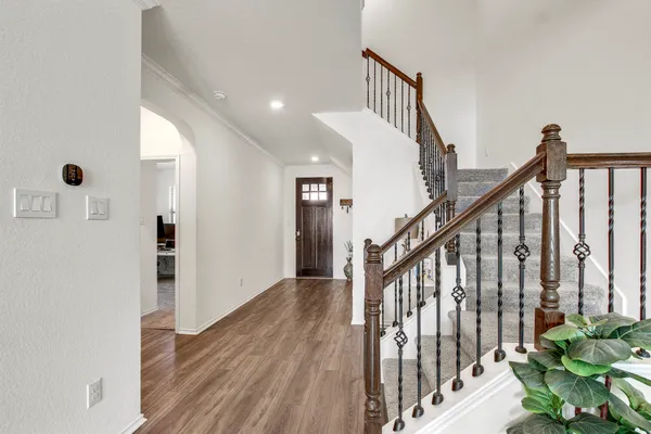 a view of a hallway with wooden floor and staircase