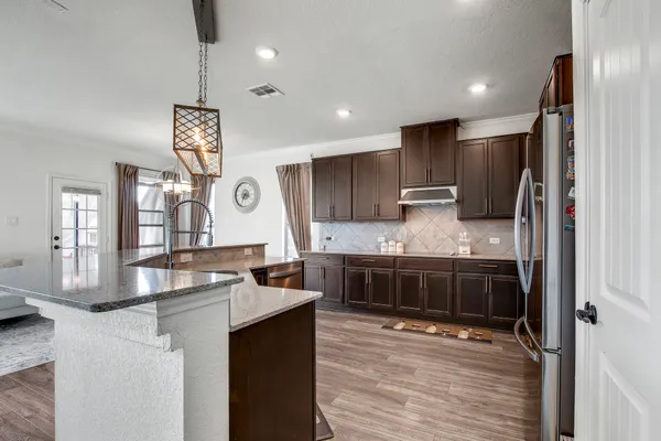 a kitchen with stainless steel appliances granite countertop a sink stove and refrigerator