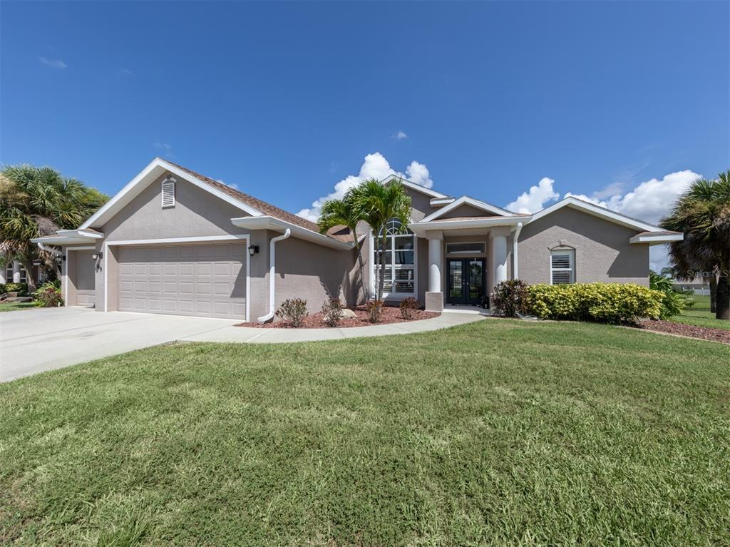 85 Marker Road Rotonda West, FL 33947 - Photo 1 of 1 a front view of a house with a yard and garage
