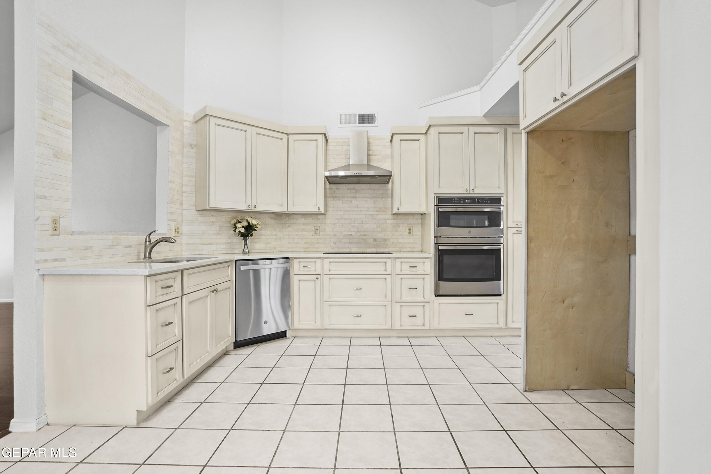 660 Rosinante Road El Paso, TX 79922 - Photo 13 of 43 a kitchen with white cabinets a sink dishwasher and a stove with wooden floor