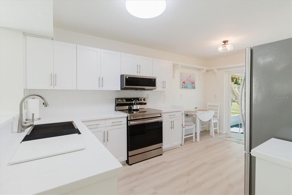 7807 Hardwick Drive, Unit 111 New Port Richey, FL 34653 - Photo 11 of 38 a kitchen with stainless steel appliances a stove a sink a microwave and a refrigerator