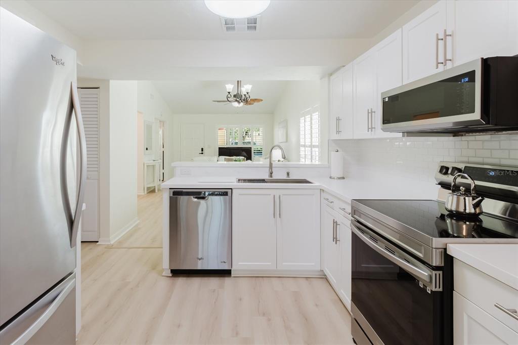 7807 Hardwick Drive, Unit 111 New Port Richey, FL 34653 - Photo 13 of 38 a kitchen with stainless steel appliances a sink stove and refrigerator