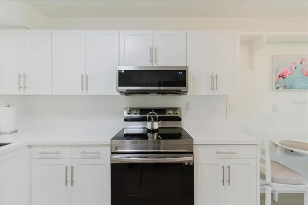 a kitchen with a stove and a white cabinets