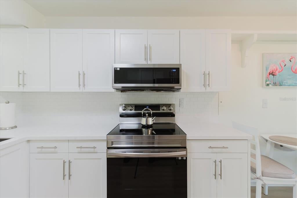 7807 Hardwick Drive, Unit 111 New Port Richey, FL 34653 - Photo 14 of 38 a kitchen with a stove and a white cabinets
