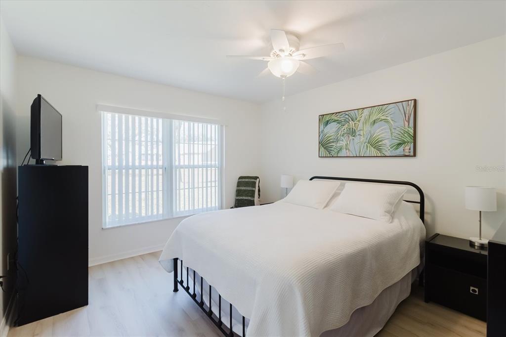 7807 Hardwick Drive, Unit 111 New Port Richey, FL 34653 - Photo 20 of 38 a bedroom with a bed and a chandelier