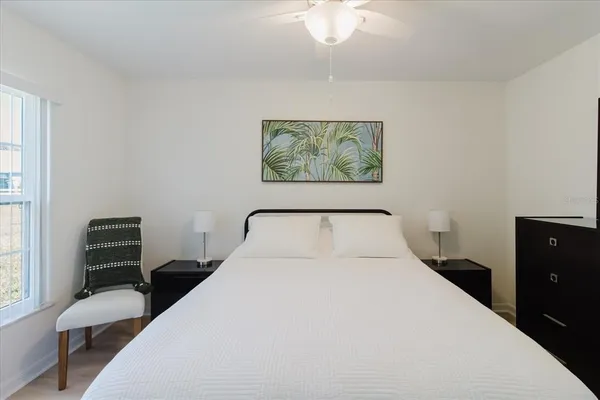 a bedroom with a bed and a painting on the wall