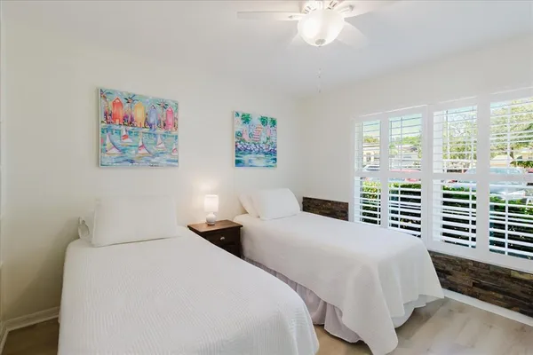 a bedroom with two beds and a large window
