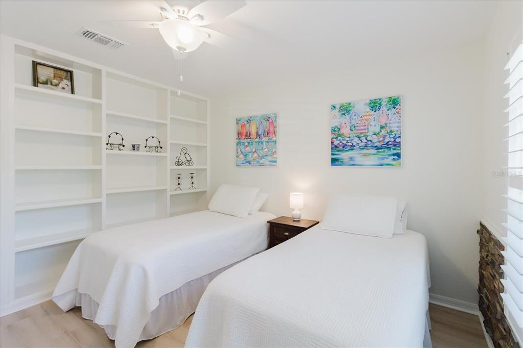 7807 Hardwick Drive, Unit 111 New Port Richey, FL 34653 - Photo 27 of 38 a bedroom with two beds and a chandelier