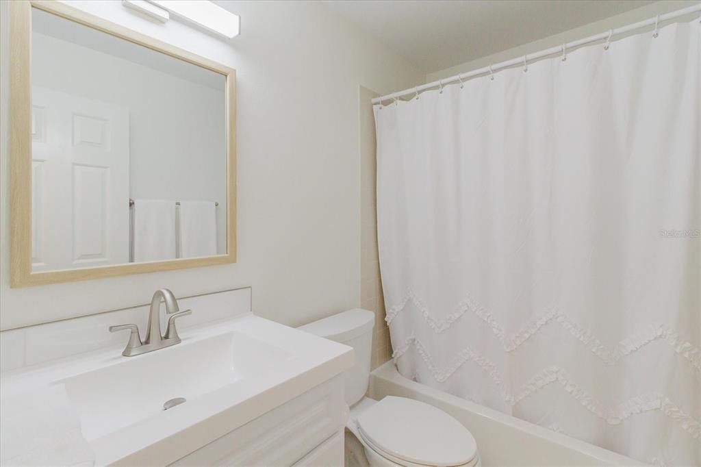 7807 Hardwick Drive, Unit 111 New Port Richey, FL 34653 - Photo 28 of 38 a bathroom with a sink toilet and a mirror