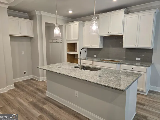 a kitchen with stainless steel appliances granite countertop a sink refrigerator and cabinets