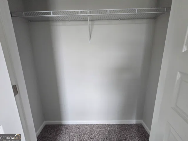 a view of swimming pool with seating area and trees in the background