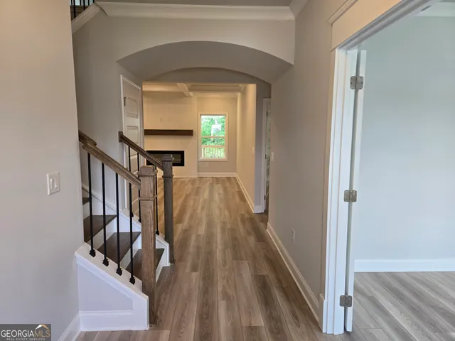 a view of a hallway with wooden floor and staircase
