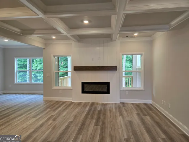 an empty room with windows and fireplace