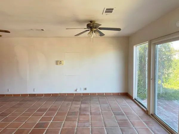 a view of a hallway with windows and chandelier