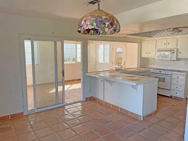 a kitchen with granite countertop white cabinets and white appliances