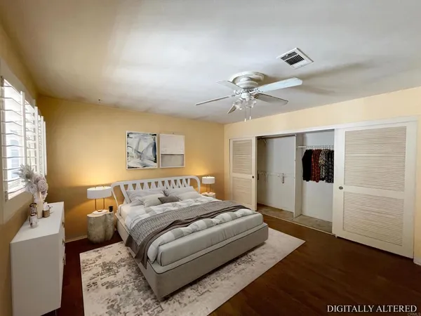an empty room with wooden floor fan and windows