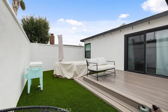 a bedroom with a large bed a painting on the wall and a potted plant