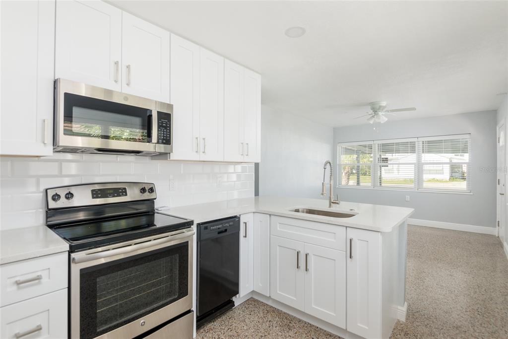13248 4th Street East Madeira Beach, FL 33708 - Photo 11 of 47 a kitchen with granite countertop cabinets stainless steel appliances and a sink