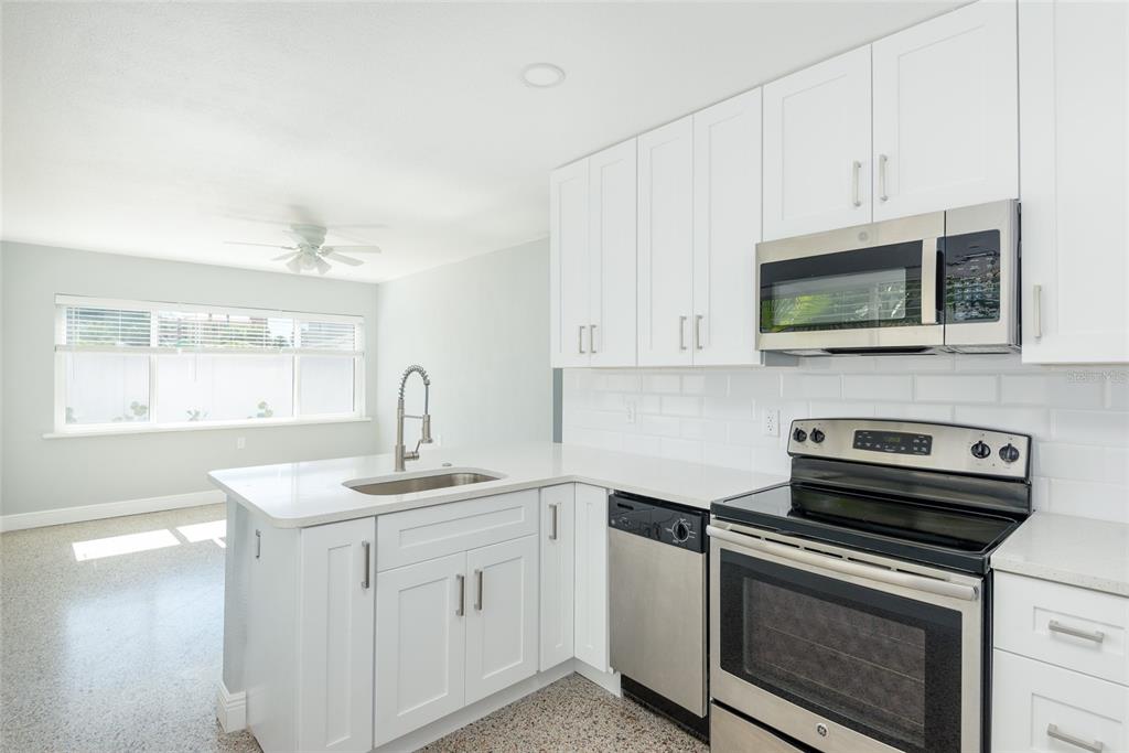 13248 4th Street East Madeira Beach, FL 33708 - Photo 23 of 47 a kitchen with appliances a sink and a microwave