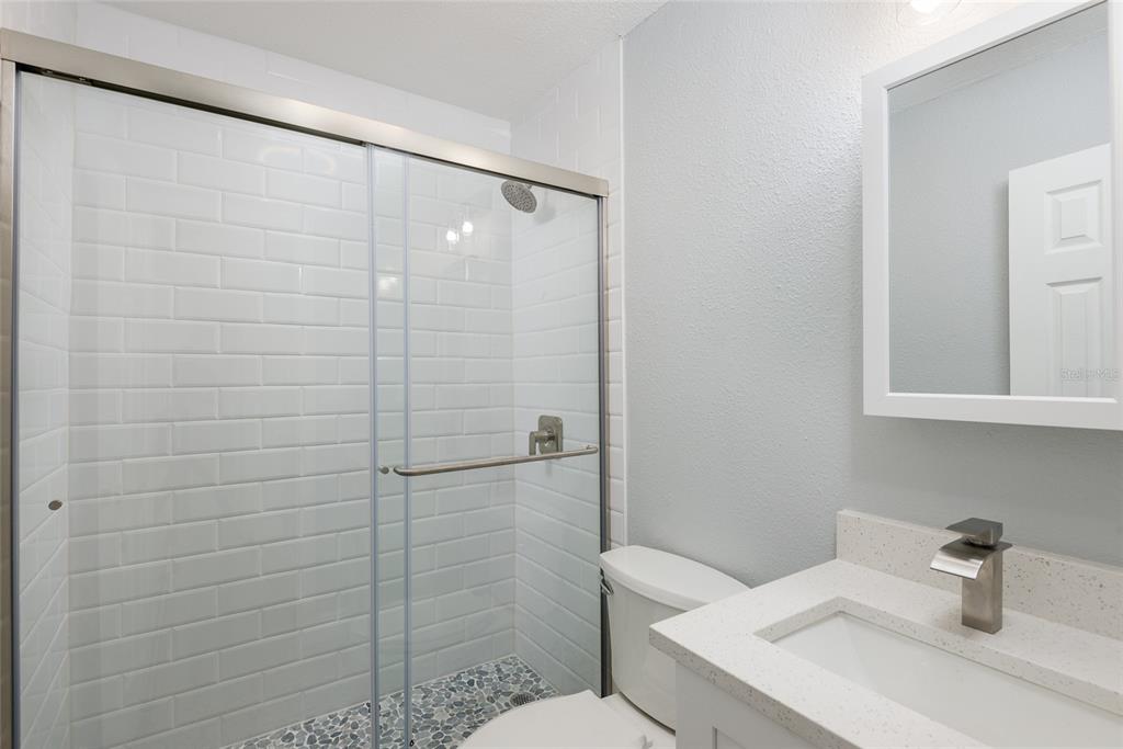 13248 4th Street East Madeira Beach, FL 33708 - Photo 27 of 47 a bathroom with a sink a toilet and shower