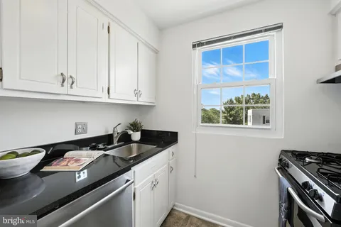 a kitchen with stainless steel appliances granite countertop a sink stove and cabinets