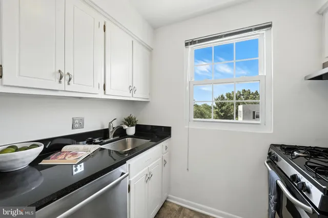 a kitchen with stainless steel appliances granite countertop a sink stove and cabinets