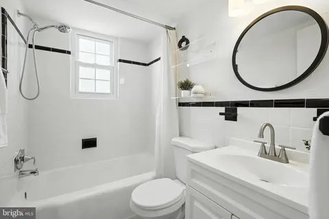 a bathroom with a sink a mirror a toilet and a bathtub