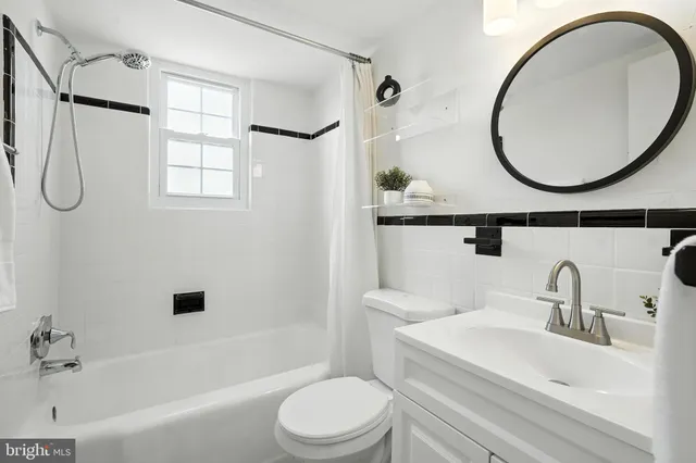 a bathroom with a sink a mirror a toilet and a bathtub