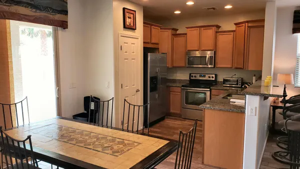 a large kitchen with a stove a refrigerator and a dining table