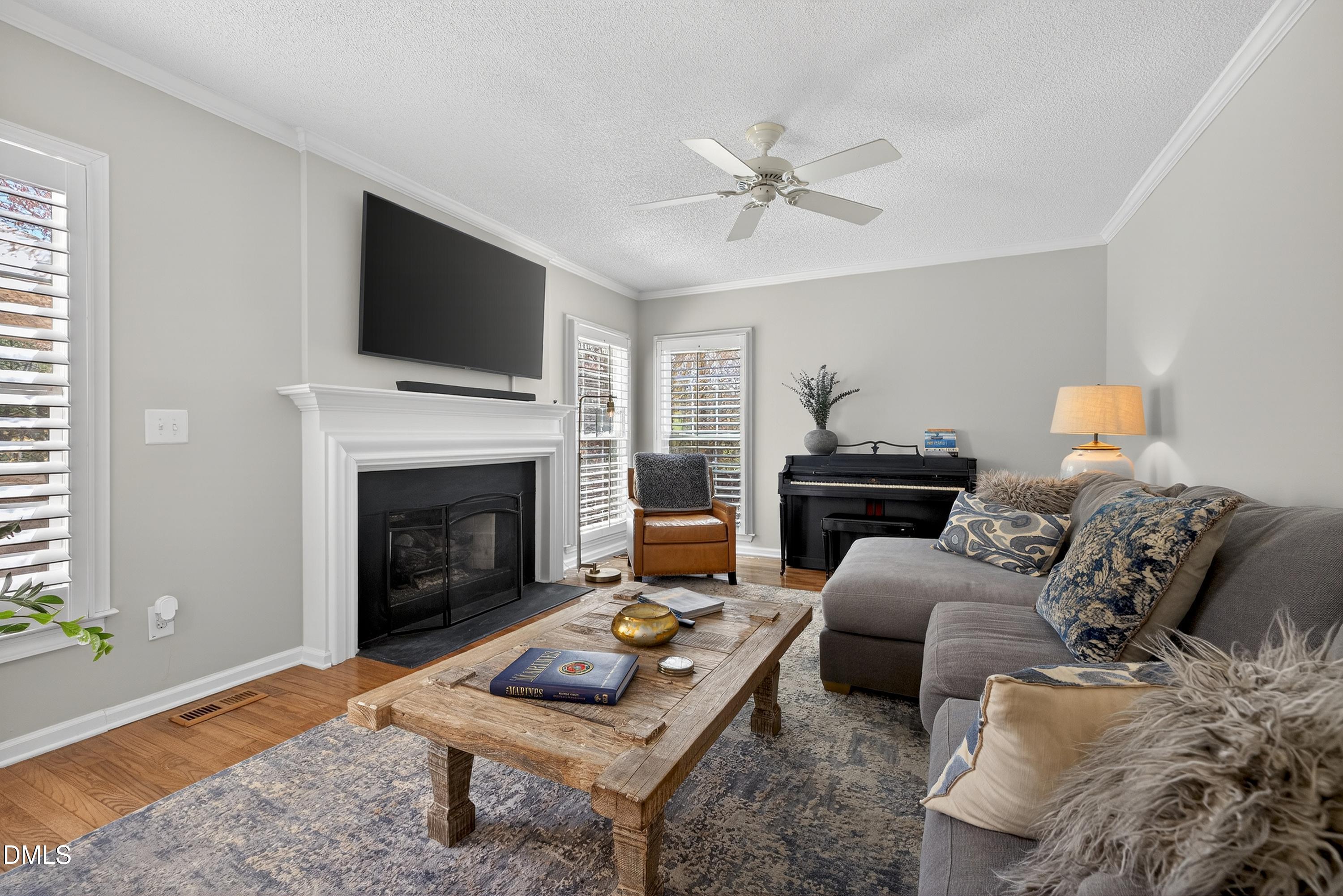 9432 Cartersville Court Raleigh, NC 27617 - Photo 25 of 66 a living room with furniture a flat screen tv and a fireplace