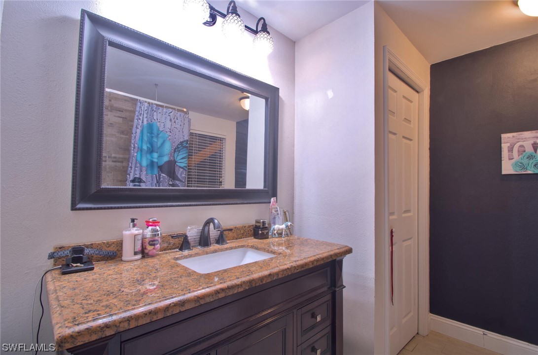 9180 Mandarin Road Fort Myers, FL 33967 - Photo 13 of 26 a bathroom with a granite countertop sink and a mirror