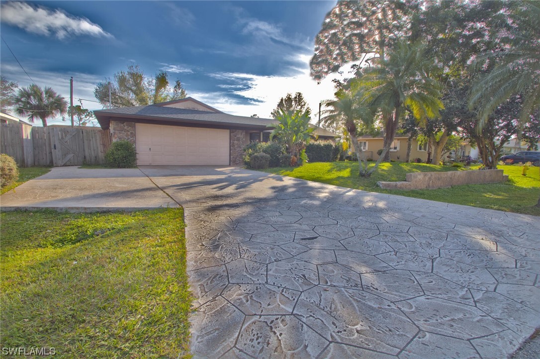 9180 Mandarin Road Fort Myers, FL 33967 - Photo 23 of 26 a view of yellow house with a yard and a large tree