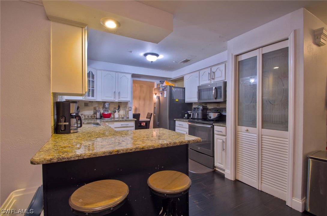 9180 Mandarin Road Fort Myers, FL 33967 - Photo 8 of 26 a kitchen with stainless steel appliances granite countertop a sink refrigerator and cabinets