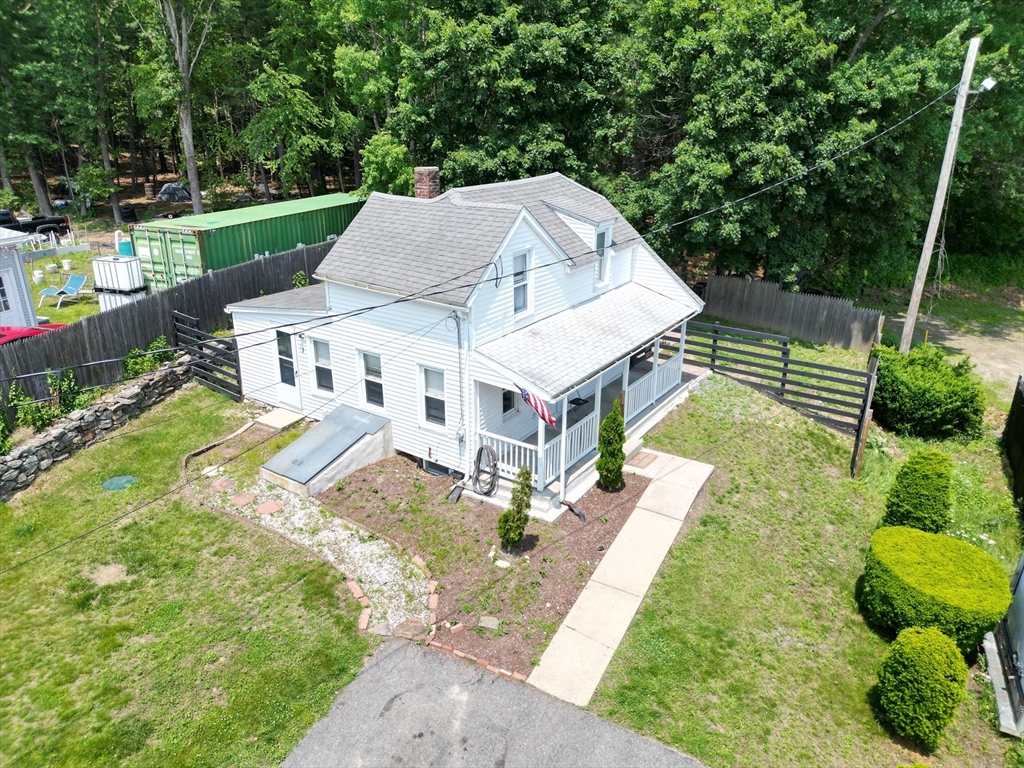 an aerial view of a house with a big yard potted plants and a large tree