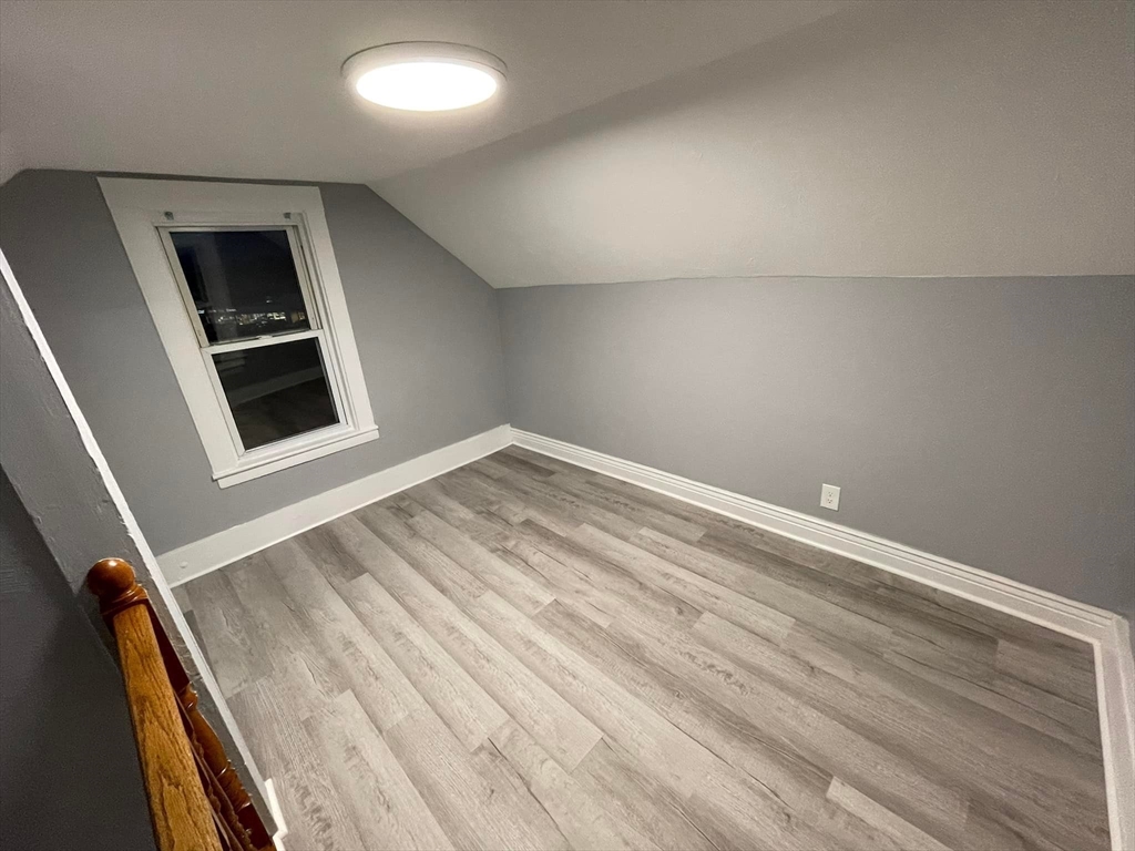 7 Coolidge Street Hudson, MA 01749 - Photo 20 of 40 a view of an empty room with wooden floor and a window