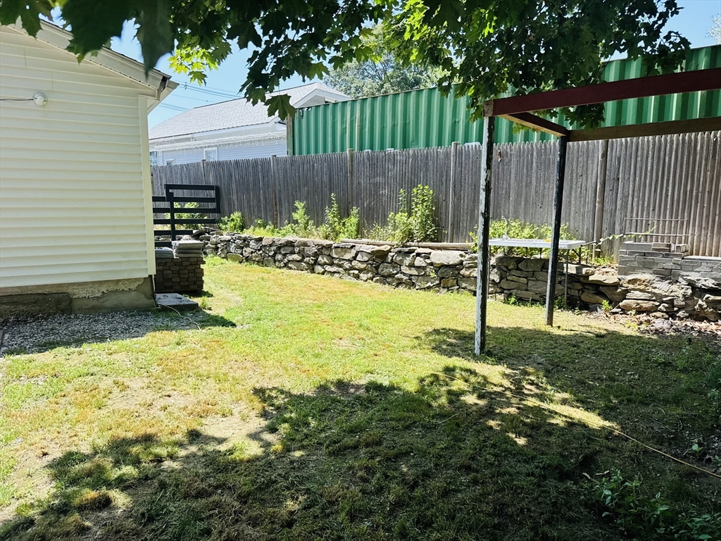 7 Coolidge Street Hudson, MA 01749 - Photo 30 of 40 a view of a backyard with a table and chairs with wooden fence