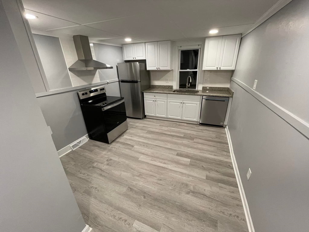 7 Coolidge Street Hudson, MA 01749 - Photo 5 of 40 a kitchen with granite countertop a refrigerator sink and cabinets