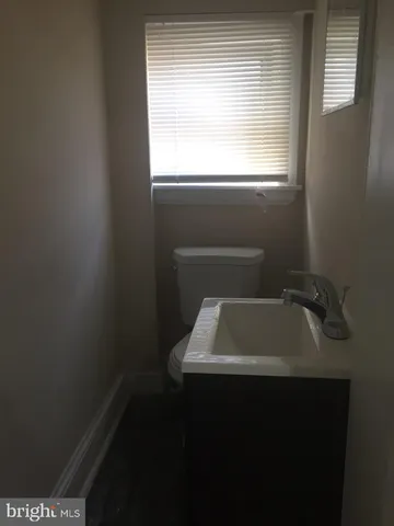 a bathroom with a sink window and cabinets