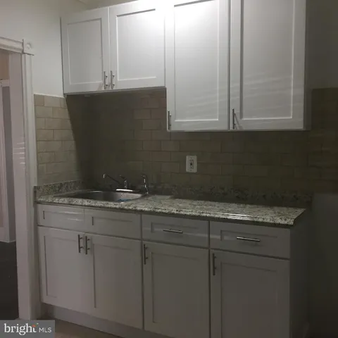 a bathroom with a granite countertop sink and a vanity