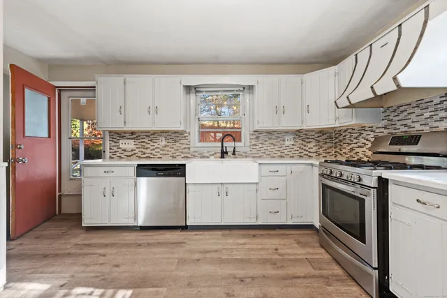 a kitchen with white cabinets stainless steel appliances and sink