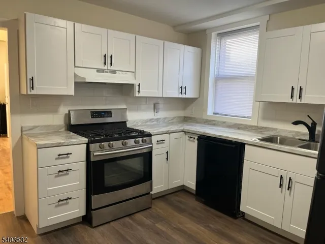 a kitchen with granite countertop white cabinets and appliances