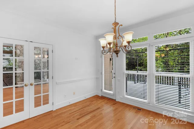 a view of a bedroom with wooden floor and windows