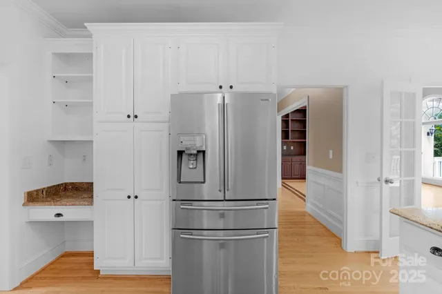 a view of kitchen with refrigerator and wooden floor