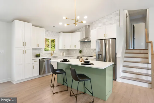 a kitchen with kitchen island white cabinets and stainless steel appliances