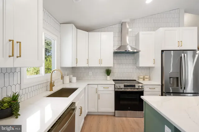 a kitchen with a sink a counter space appliances and cabinets