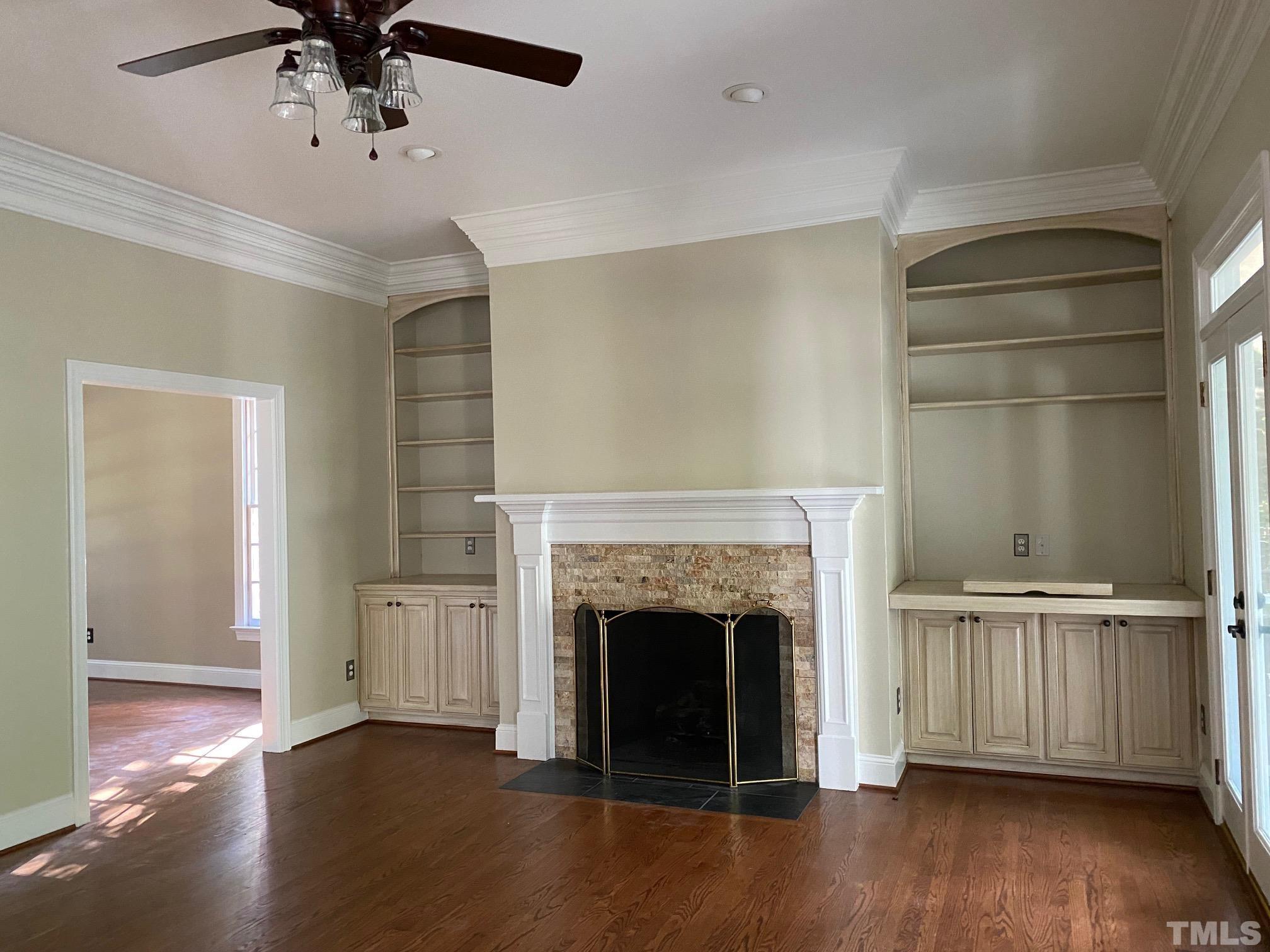 7705 Rainwater Road Raleigh, NC 27615 - Photo 16 of 18 a view of a livingroom with a fireplace a ceiling fan and windows