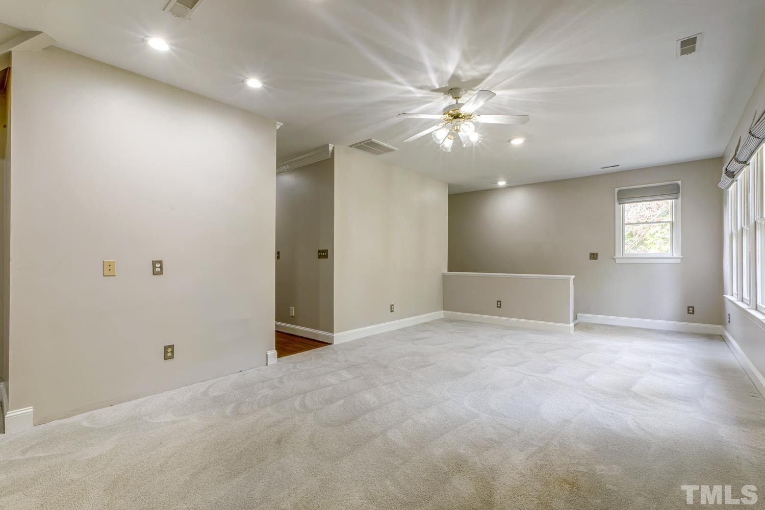 7705 Rainwater Road Raleigh, NC 27615 - Photo 10 of 18 an empty room with chandelier fan and windows