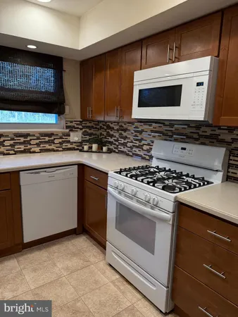 a white stove top oven sitting inside of a kitchen