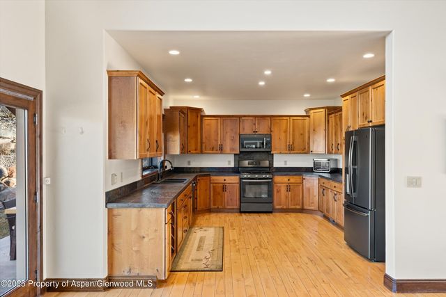 a large kitchen with stainless steel appliances lots of counter space and a sink