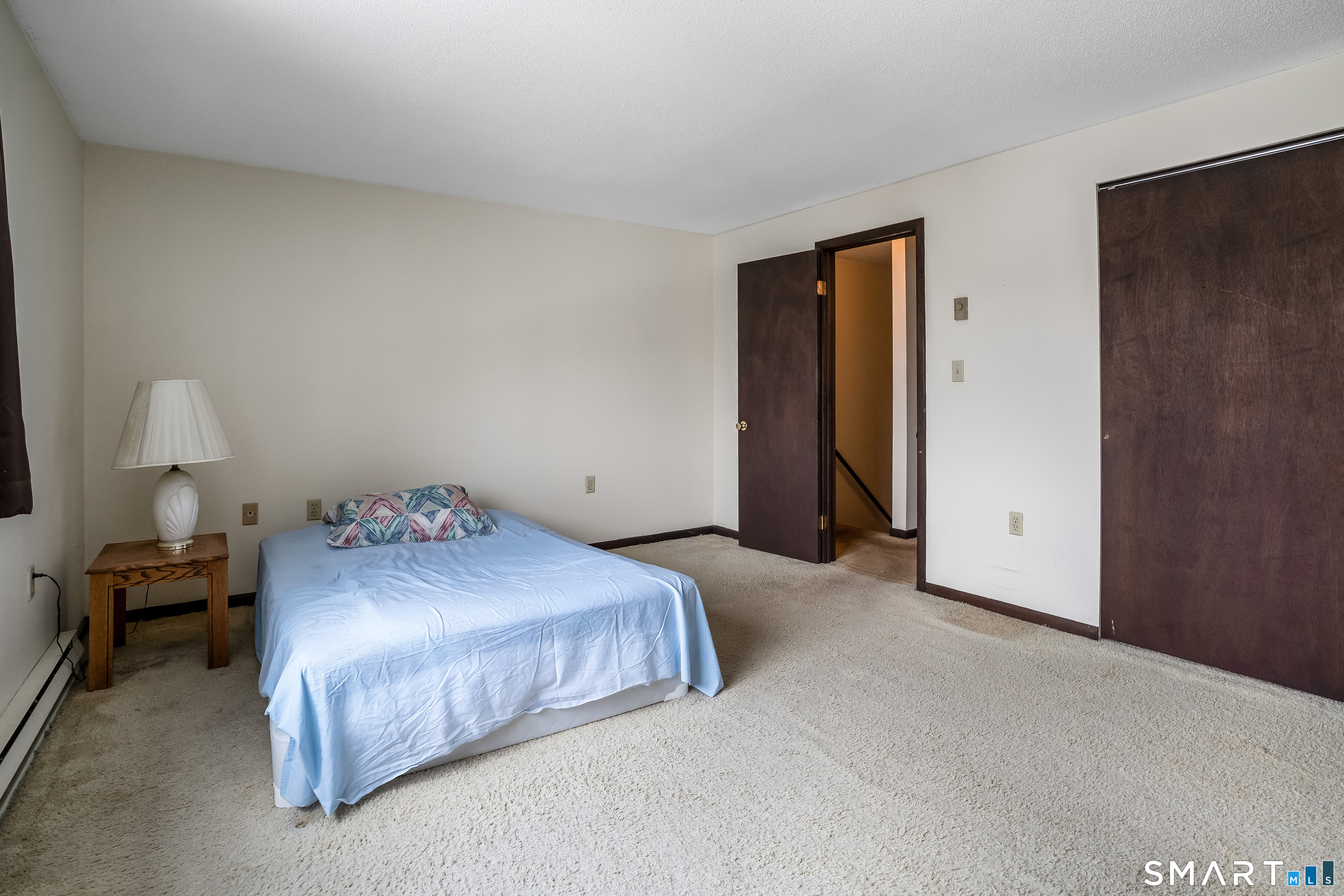461 Spring Street, Unit 3B Naugatuck, CT 06770 - Photo 5 of 13 a bedroom with a bed and a lamp
